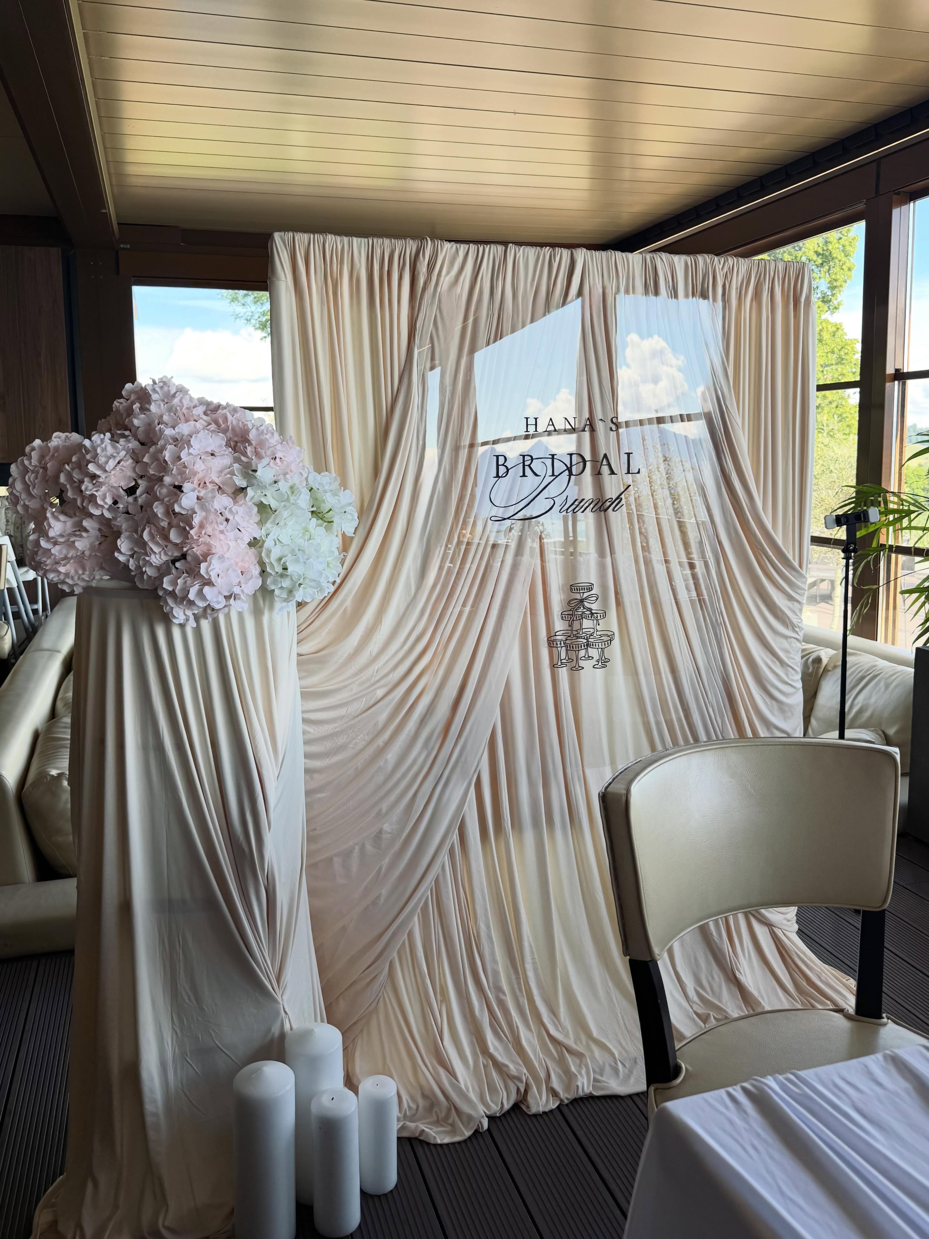 Eleganter Bridal-Brunch-Hintergrund mit fliessenden Stoffen und hellen Blüten