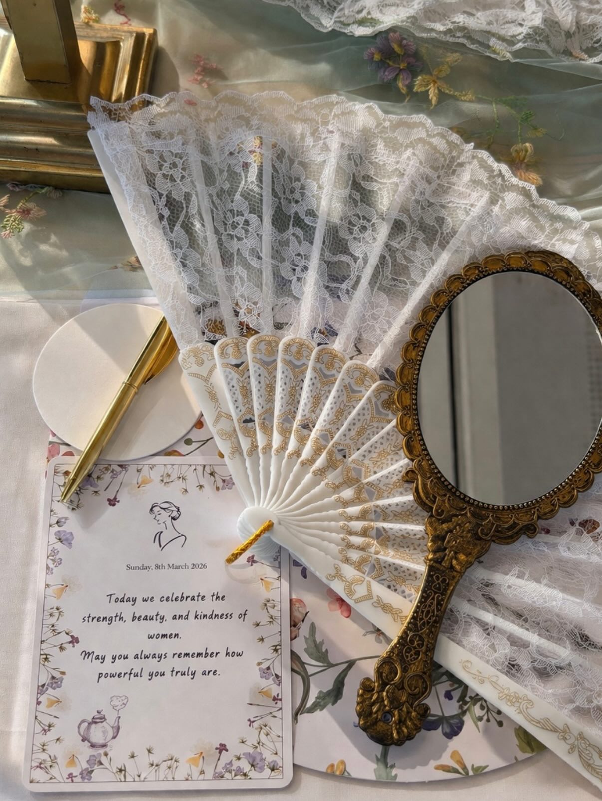 Feine Spitze, goldener Handspiegel und liebevoll gestaltete Tischdetails